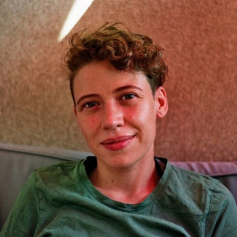 Cin Pietschmann with short hair dressed in green sitting and smiling