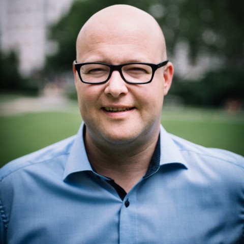 Leonhard Dobusch Mann mit Brille und blauem Hemd lächelt in die Kamera