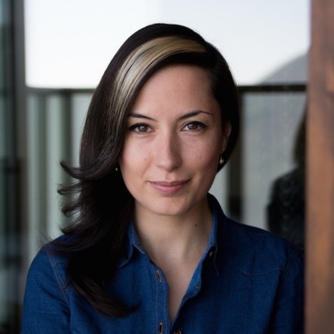Nadia Zaboura long dark hair dressed in dark blue smiling lightly