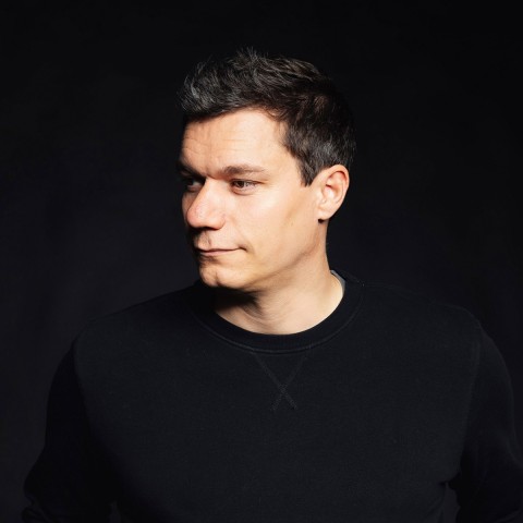 Dennis Horn vor einem sehr dunklen Hintergrund