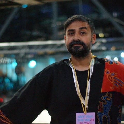 Foto von Saad. Er trägt ein teils gemustertes Oberteil und ein Lanyard der re:publica.
