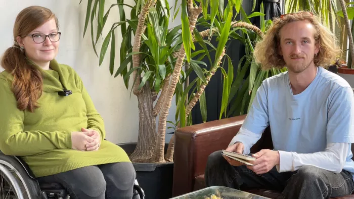 Judyta Smykowski (Sozialheld*innen) und Francis aus dem #rp22-Team sitzen nebeneinander und schauen in die Kamera für ein Interview.