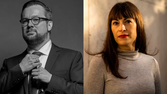 Foto von Oliver Nachtwey & Carolin Amlinger. Beide schauen in die Kamera. Oliver Nachtwey hält seine Hände an einer Krawatte und trägt Brille. Carolin Amlinger trägt einen Rollkragenpullover, Pony und Lippenstift