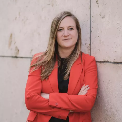 Carmen Wegge, MdB, trägt einen roten Blazer und hat die Arme verschränkt