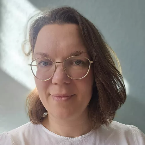 Eine Frau mit Brille und mittellangen Haaren