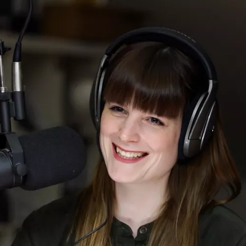 Janina Zillekens-McFadden bei der Aufnahme einer Podcast-Folge. Sie trägt Kopfhörer, vor ihr ist ein Mikrofon.