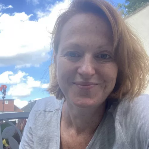 Smiling blond woman in front of blue sky
