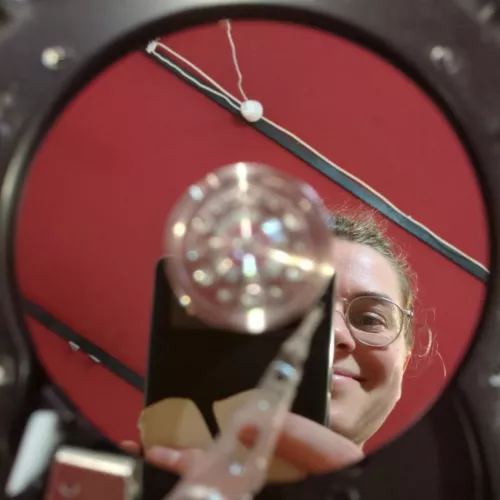 Foto einer aufgebrochenen Festplatte, in der Reflektion der Datenscheibe sieht man Lisa wie sie das Foto macht