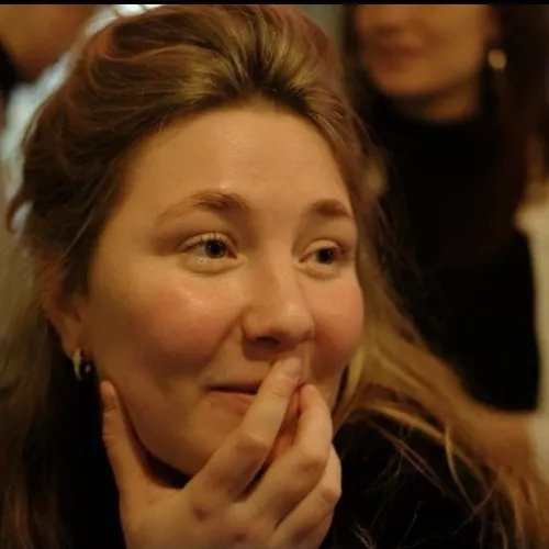 Frau schaut nach rechts und lächelt 